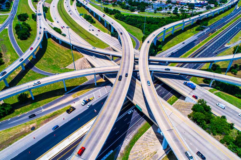 Bird's eye view image of a group of freeways with cars.