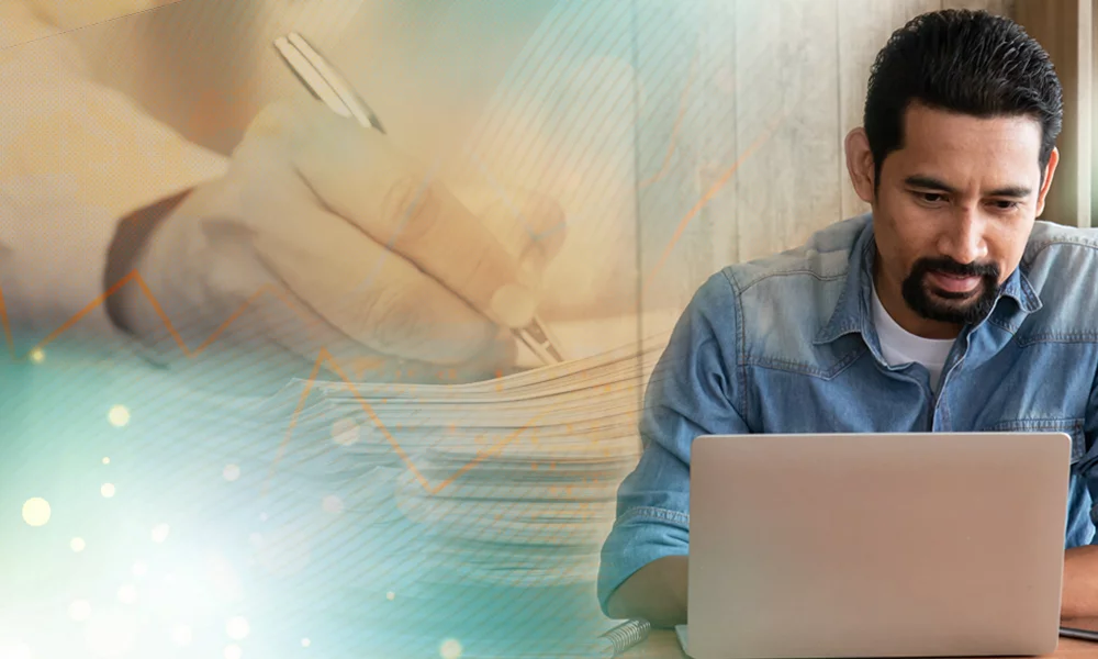 Image of a man working on his computer as an image of someone signing a stack of papers is in the back. 