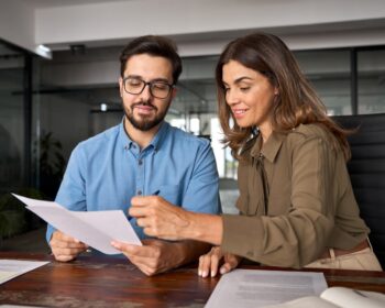 Two people deciding best factoring companies for their cashflow needs.