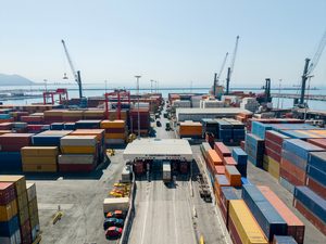 Invoice Factoring Challenges in the Transportation Industry 3 Shipping containers and cranes at a busy freight terminal and commercial port